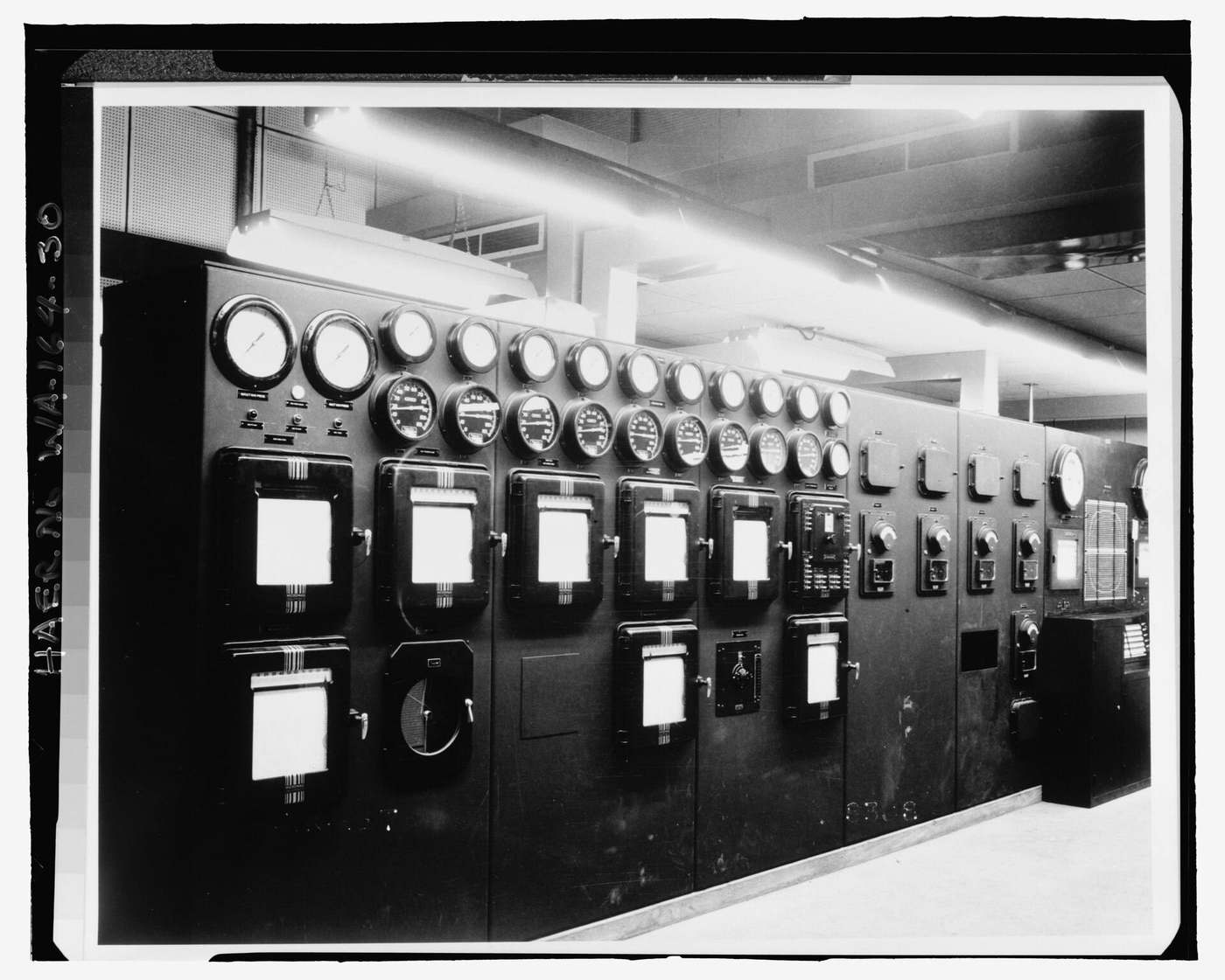 A wall of round gauges and strip-chart recorders in a 1945 control room.